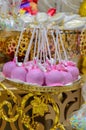 The pastry chef decorates cake pops with satin ribbons. Desserts with pink cream. Royalty Free Stock Photo