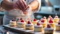 Pastry chef decorating small cakes with strawberries and whipped cream in a commercial kitchen Royalty Free Stock Photo