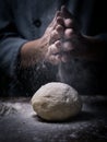 pastry chef hand sprinkling white flour over Raw Dough on kitchen table. Royalty Free Stock Photo