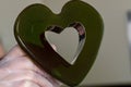 A pastry chef holds a heart-shaped caramel candy just made