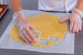 Pastry chef in the kitchen makes cookies. Cook cuts cookies from rolled dough using a cookie cutter. Master class in the kitchen. Royalty Free Stock Photo