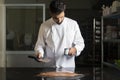 Pastry chef measuring the temperature of the chocolate with an infrared thermometer, working on the tempering of the chocolate