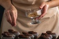 Pastry chef prepares chocolate mousxes with nut filling. Process of cooking cocoa muffins