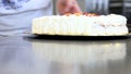 Pastry chef prepares fruit cake with whipped cream