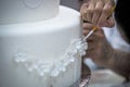 Pastry chef preparing a 3 tier frosted layered wedding cake decorated. Royalty Free Stock Photo