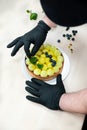 pastry chef puts blueberries on pistachio shortbread tart with whipped green cream