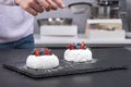 Pastry chef sprinkles icing sugar on berry cakes. Cakes Anna Pavlova