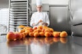 Pastry chef at work in professional kitchen, makes apricot jam for the cake or for the croissants, on stainless steel worktops