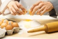 Pastry dough - chef cracking egg over flour heap