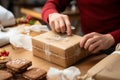 Pastry packaging: Confectioner\'s hands expertly encase cardboard box in close-up, showcasing skilled artistry.