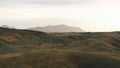 Pasture along the winding narrow road on a foggy morning. Shot. Aerial of stunning hills and growing rare bushes in Royalty Free Stock Photo