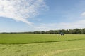 Pasture mowing with blue tractor Royalty Free Stock Photo