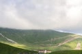 Pasture with rams and sheeps on the mountain at the road in Georgia on a misty sky background. Royalty Free Stock Photo