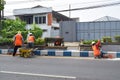 Workers repairing traffic lane dividers and separators made of concrete on asphalt roads