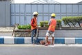 Workers repairing traffic lane dividers and separators made of concrete on asphalt roads