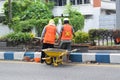 Workers repairing traffic lane dividers and separators made of concrete on asphalt roads. Royalty Free Stock Photo