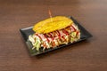 Patacon stuffed with everything, ham, lettuce, stewed pulled chicken meat, fresh cheese, plantain and ketchup Royalty Free Stock Photo