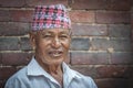 Unidentified Newari elderly man sit in front of the Mul Chowk Royal Palace in Patan Durbar Square - Nepal