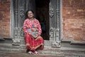 Unidentified Newari elderly woman sit in the courtyard of Keshav Narayan Chowk in Patan Royal Palace in Patan Durbar Square Nepal