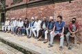 Unidentified Newari men sit in front of the Mul Chowk Royal Palace in Patan Durbar Square - Nepal