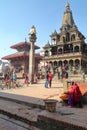 PATAN, NEPAL - DECEMBER 19, 2014: Garuda statue on column and Krishna Mandir temple at Durbar Square