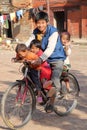 PATAN, NEPAL - DECEMBER 21, 2014: A smiling family with three cute children on a bicycle