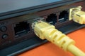 Patch cords are yellow inserted into the ports of the router to access the Internet. router on a blue background