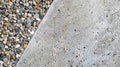 A patch of exposed aggregate reveals tiny pebbles and grains embedded in the concrete adding depth and texture to the