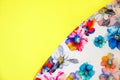 A patch of white fabric with multicolored flowers on a bright yellow background. Space for text