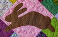 Patchwork quilt featuring a stylized rabbit silhouette in brown fabric with small dots Royalty Free Stock Photo