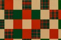A patchwork of red, green, and tan solid and plaid squares. Christmas quilt or holiday wrapping paper pattern banner Royalty Free Stock Photo