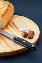 Pate, bread, hazelnuts and knife on wood plate