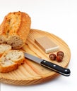 Pate, bread, hazelnuts and knife on wood plate