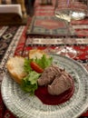 Pate with salad and bread loaf on a round gray plate