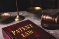 Patent Law book and gavel on grey marble table, closeup
