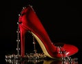 Patent leather shiny female red stilettos and beads on a black background Royalty Free Stock Photo