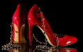 Patent leather shiny female red stilettos and beads on a black background Royalty Free Stock Photo