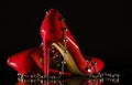 Patent leather shiny female red stilettos and beads on a black background Royalty Free Stock Photo