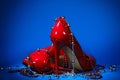 Patent leather shiny female red stilettos and beads on a blue background Royalty Free Stock Photo