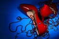 Patent leather shiny female red stilettos and beads on a blue background Royalty Free Stock Photo