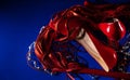 Patent leather shiny female red stilettos, whip and beads on a blue background Royalty Free Stock Photo