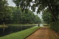 Path amidst wooded gardens and canal on rainy day around De Haar Castle, near Utrecht.