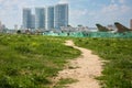 Path between fresh green grass goes to old soviet military airplanes with red stars and modern buildings