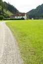 Path Through Green Meadow with Forest in the Background and Beautiful House Royalty Free Stock Photo