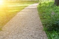 The path through the green summer park. Gray gravel pathway in a summer park at sunset. The concept of travel Royalty Free Stock Photo