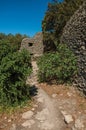 Path and huts made of stone under sunny blue sky, in the Village of Bories, near Gordes.