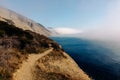 The path through the juniper forest of Utrish Nature Reserve runs along the edge of a high mountain shore above the blue sea, over