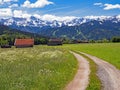 A path leads through the countryside of Upper Bavaria near the village of Farchant towards the Wetterstein Mountains, Bavaria,