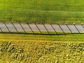 Path in a park by field, Fence cast strong shadows, Aerial top view. Royalty Free Stock Photo