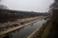 Path in a park next to a diversionary channel on a cloudy day in winter Royalty Free Stock Photo